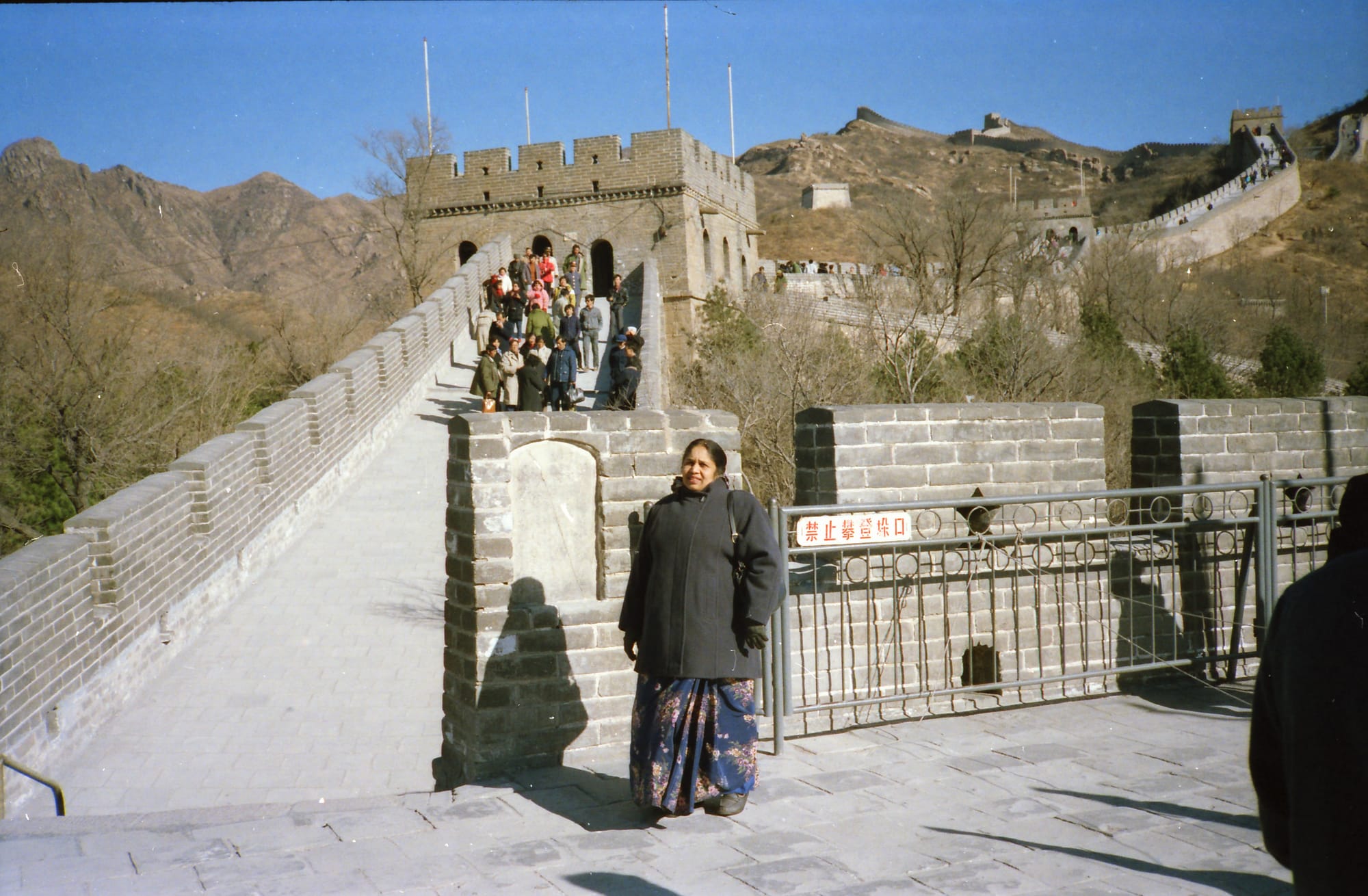 Mataji in a charcoal wool overcoat. The Great Wall of China, at Badaling