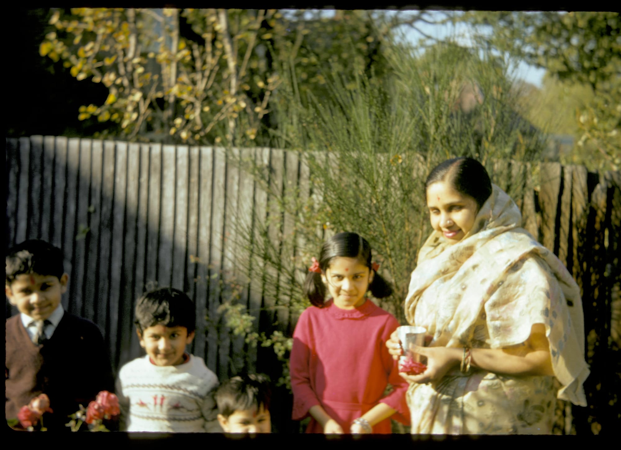 Mataji and children in tilaks. An English back garden
