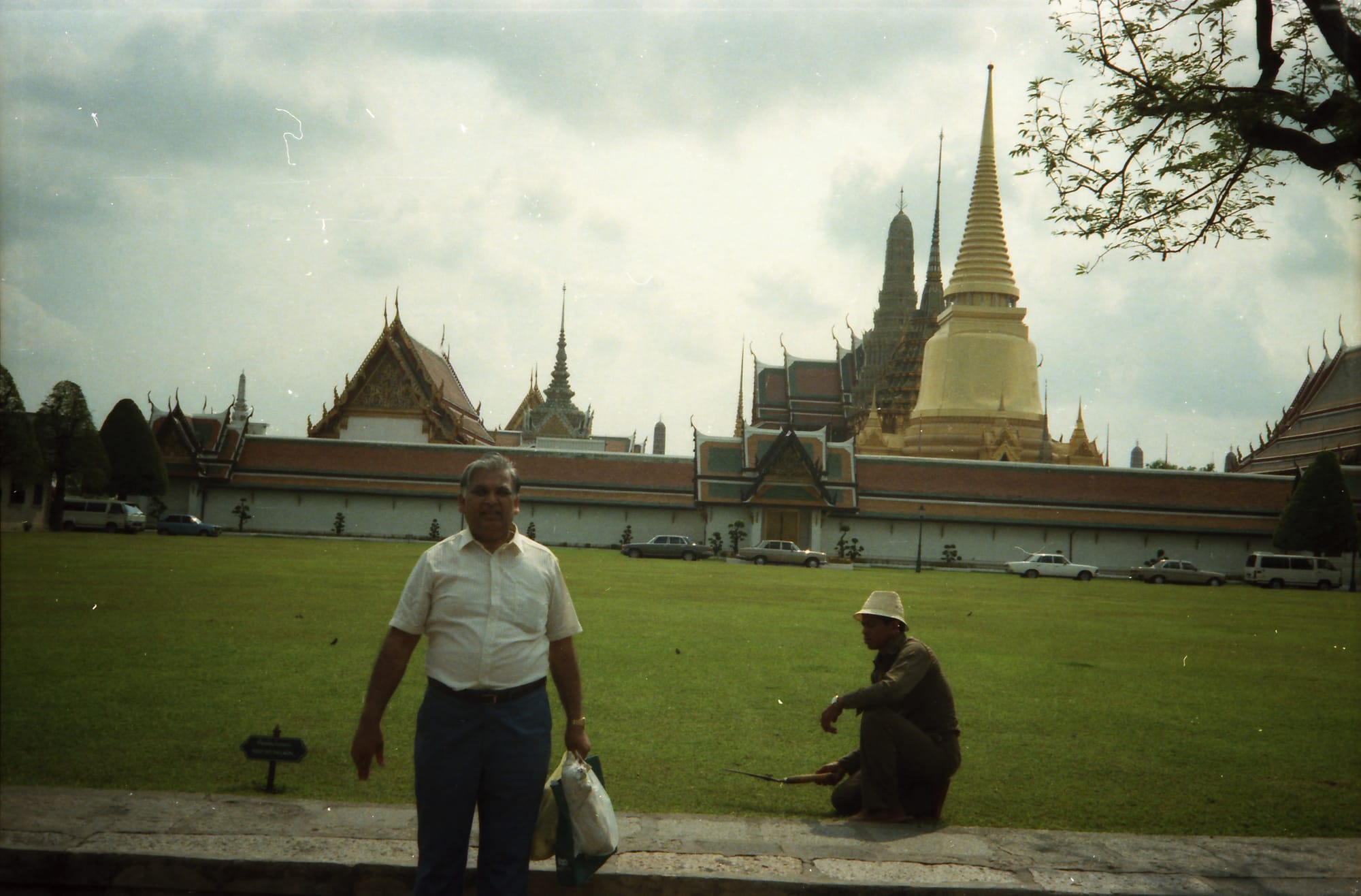 Papaji, and a second person squatting on the lawn behind him. The Grand Palace, Bangkok