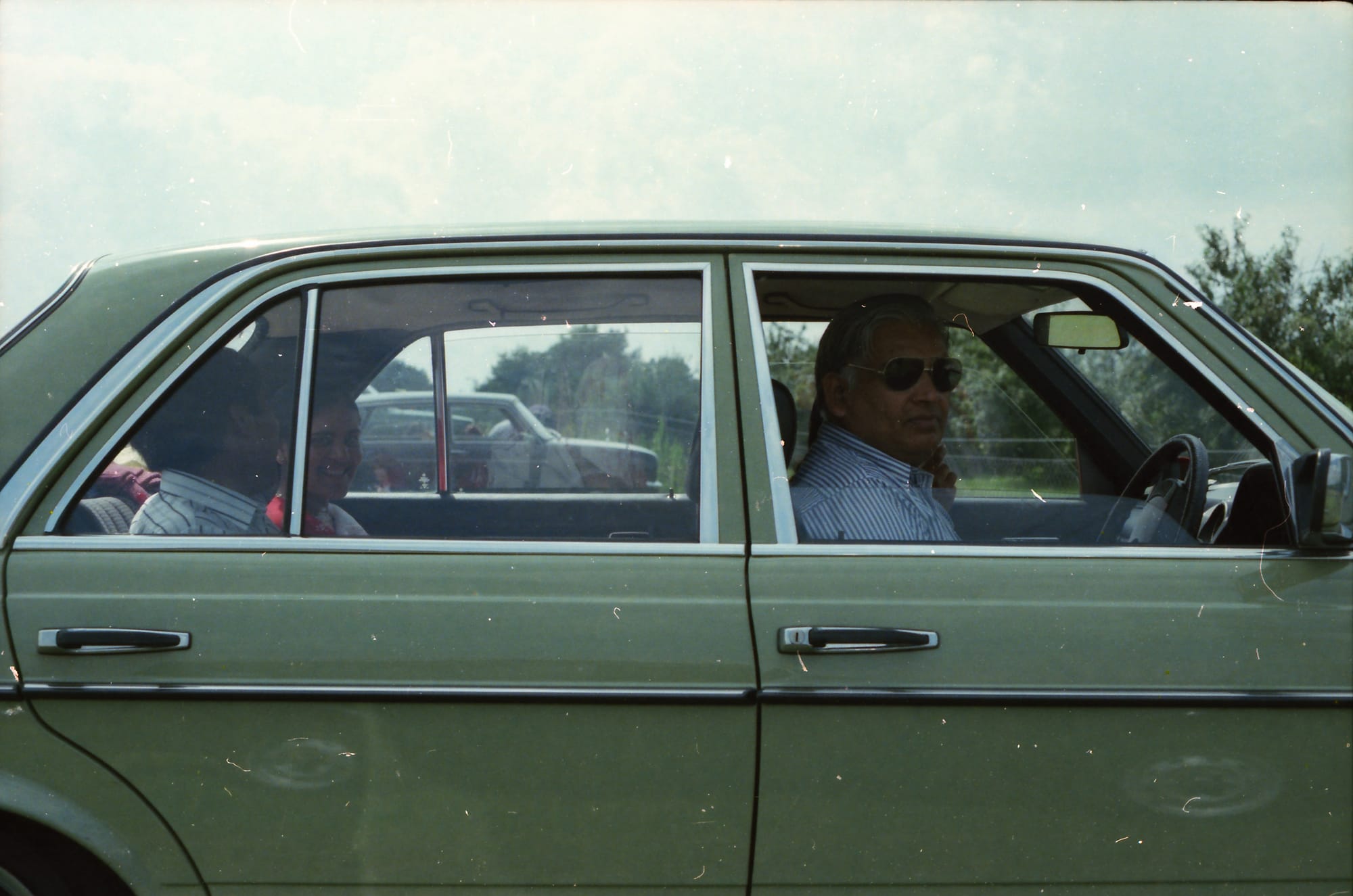 Papaji at the wheel, an adult woman in the back, and the back of another adult head. England