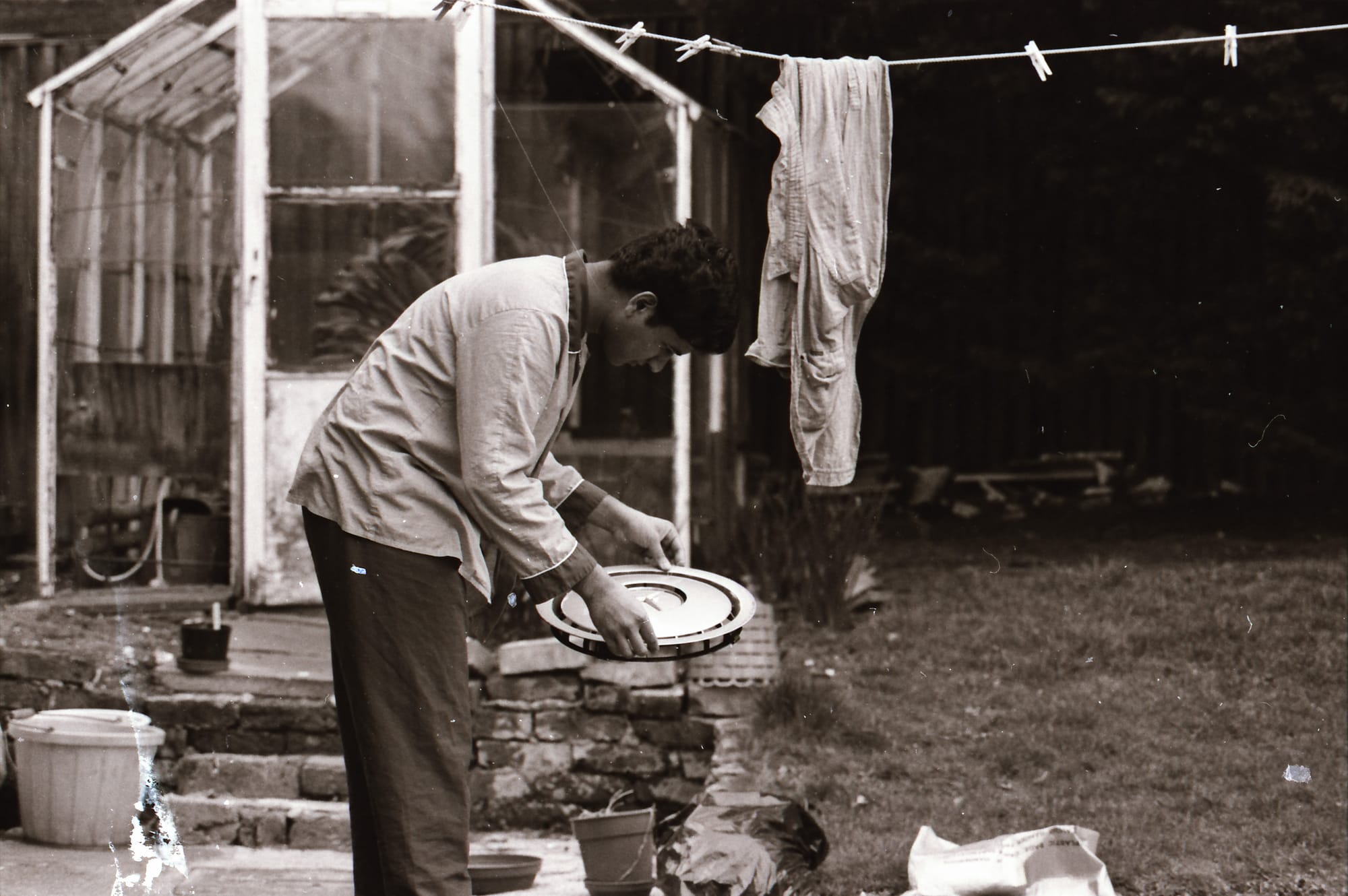 Sunil, cleaning a hubcap. An English back garden