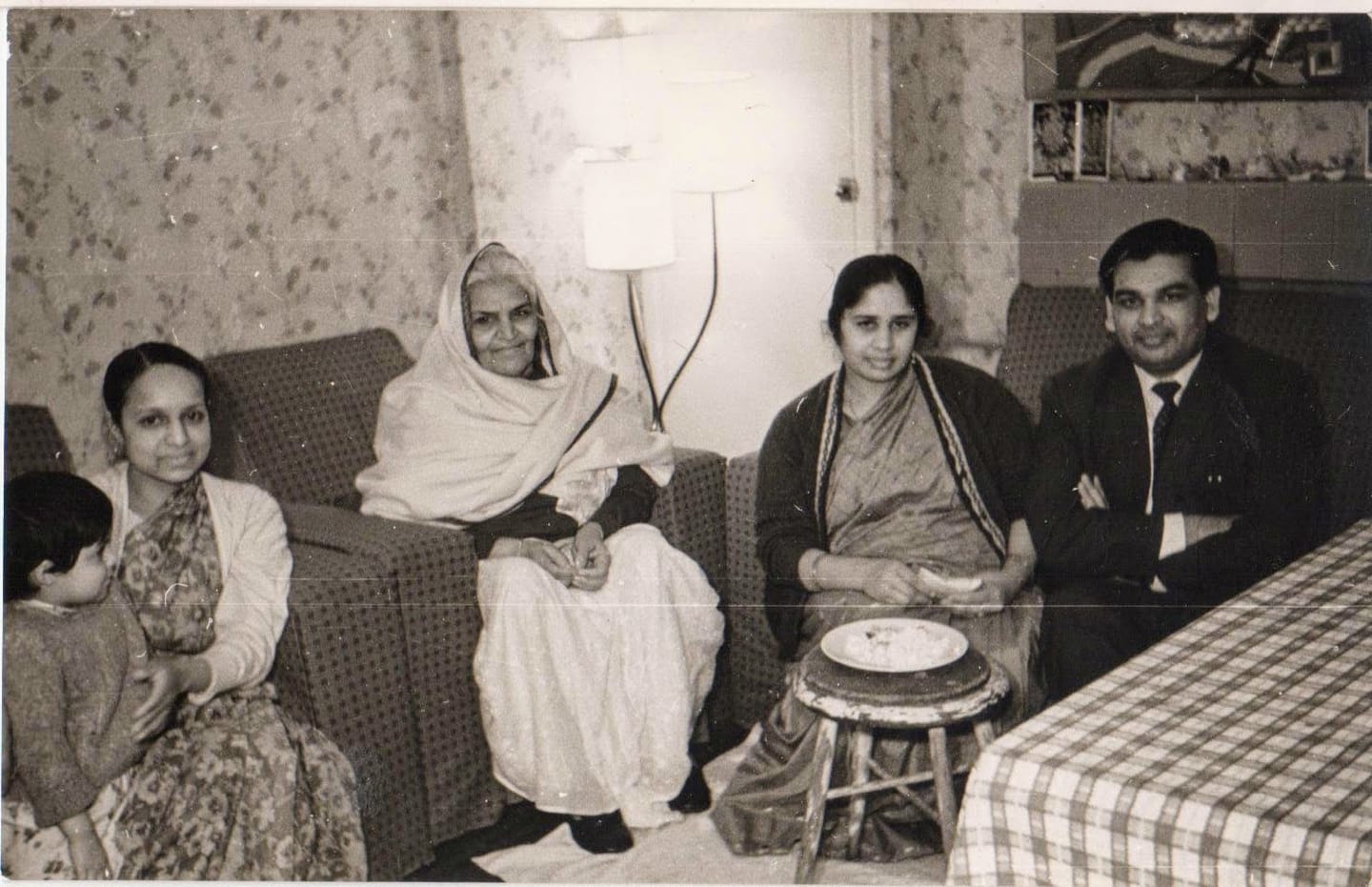 At the Agarwals' house: Papaji, Papaji's mother (the lady in the big white sari), Mataji (in the sari, beside Papaji), and Mrs Agarwal (in the cardigan, holding the child). The Agarwals’ house, London